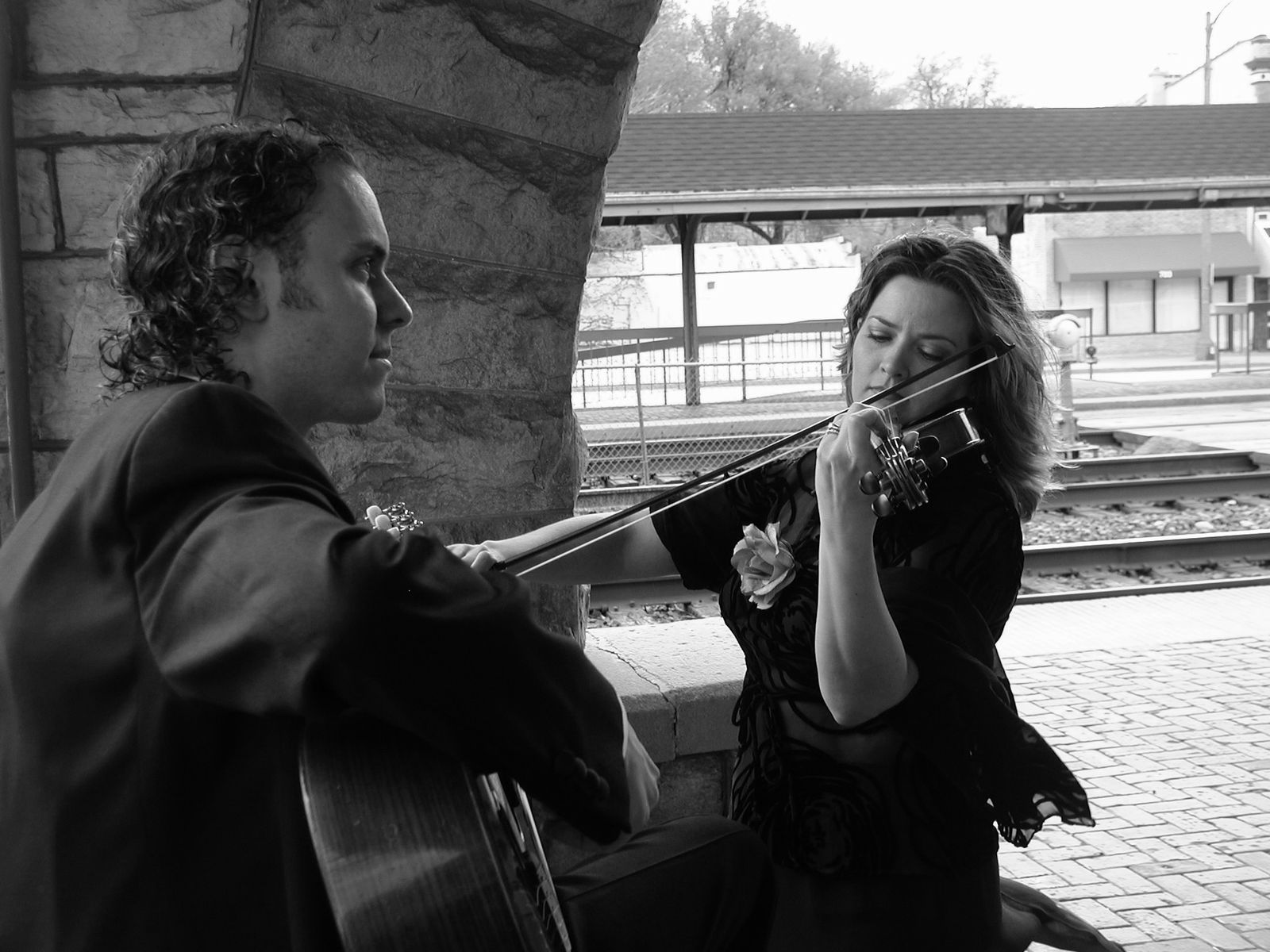 Sherri and Jason performing beside a stone wall